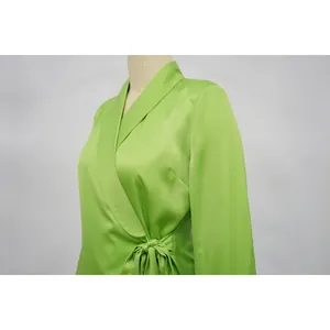 Close-up of elegant lime green satin wrap top with lapel collar and waist tie detail