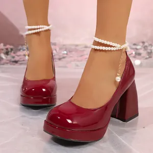 Gros plan sur des escarpins à plateforme en cuir verni bordeaux avec perles aux chevilles.