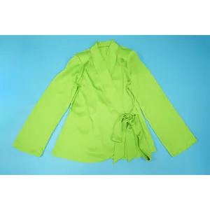 Detailed view of lime green satin wrap top featuring blazer collar and elegant side tie