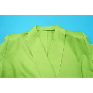 Close-up detail view of the elegant lime green shawl collar on a women's fashion blazer top