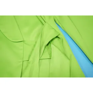 Detailed macro view of a lime green notched lapel blazer featuring an elegant waist tie design