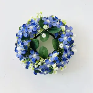 Dettaglio di una ghirlanda di fiori artificiali blu e bianchi con foglie verdi realistiche