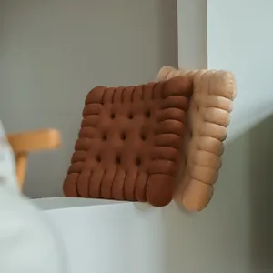 Detailed view of plush biscuit-shaped cushions in brown and beige soft velvet fabric