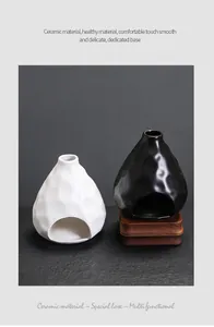 Primer plano de quemadores de salvia de cerámica blanca y negra con base de madera
