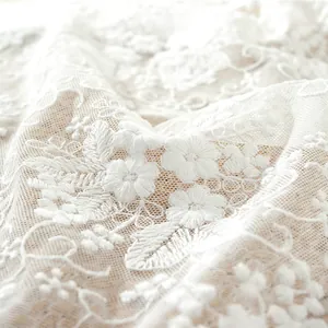 Detalle en primer plano del bordado floral en 3D blanco del camino de mesa de encaje francés