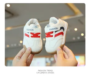 Detailansicht von weißen Baby-Lauflernschuhen mit weichen Gummisohlen und roten Streifen