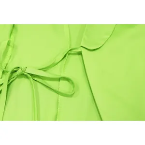Close-up detail of lime green blazer collar top with tie-up waist and neat stitching
