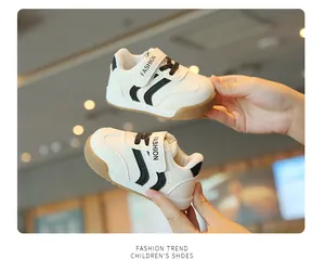 Detailansicht weißer Kleinkind-Sneaker mit schwarzen Streifen und weichen Gummisohlen.