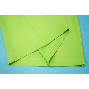 Macro view of the high-quality hem and precision stitching on neon green wide-leg trousers