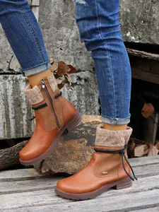 Gros plan de bottines en cuir marron pour femme avec revers en tricot et cordes sur bois rustique.