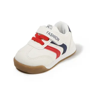 Witte peutersneakers met rode en blauwe strepen en een zachte, antislip rubberen zool