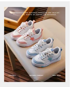 Détail de baskets pour enfants roses et bleues à motifs d'étoiles sur une chaise.