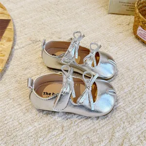 Nahaufnahme von silbernen Mädchen-Mary-Janes mit Schleifen und Tabi-Zehen-Design