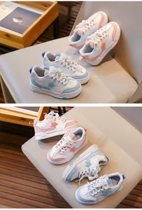 Vue détaillée de baskets pour filles roses et bleues avec étoiles sur une chaise beige