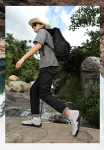 Breathable outdoor hiking shoes for men shown in use trekking through a rocky stream.