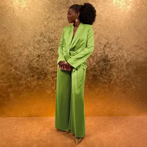 Elegant lime green satin wrap top and wide-leg pants ensemble set against a gold background