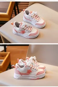 Vue latérale de baskets élégantes pour filles rose et blanc avec détail d'étoile