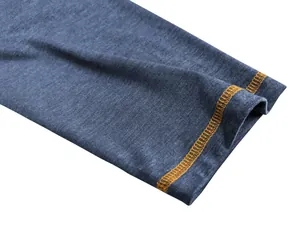 Detailopname van de manchet van een blauwe herenpolo met oranje contrasterende naden