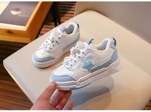 Gros plan de baskets bleu clair et blanc pour filles avec un patch en forme d'étoile