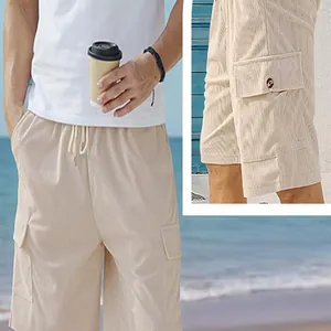 Detail view of men's beige corduroy cargo shorts featuring functional side pockets.