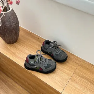 Gros plan de chaussures de marche pour tout-petits grises et respirantes sur escalier
