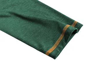 Gedetailleerde macro-opname van groene polo-manchet met oranje contrasterende stiksels.