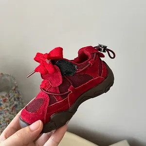 Close-up of red mesh children sneakers with bow tie lace and adjustable heel buckle