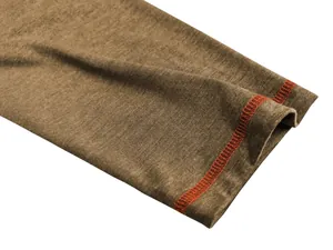 Detailopname van een bruine polo met lange mouwen en oranje contraststiksels.