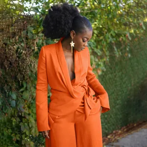 Professional detail view of a bright orange wrap-style blazer and wide-leg trousers set