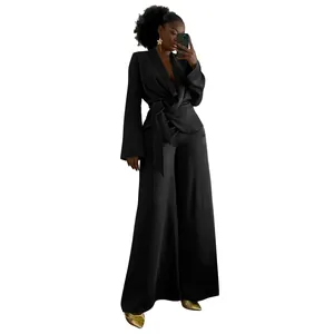 Detail of elegant black two-piece set with wrap blazer top and wide-leg trousers