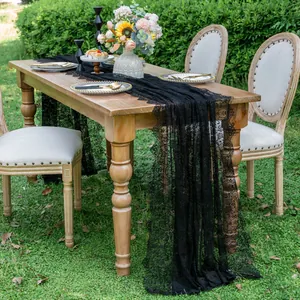 Detail view of a black lace table runner showcasing floral texture on an outdoor table.