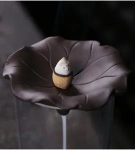 Detailed macro view of backflow incense smoke on a ceramic lotus leaf shaped burner