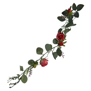 Detailed view of artificial pink rose and green eucalyptus vine garland for wall decor