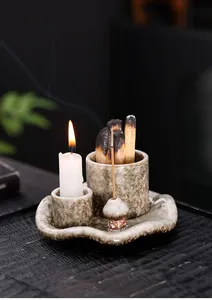 Detalle de candelabro de cerámica con Palo Santo ardiendo y soporte incienso de seta