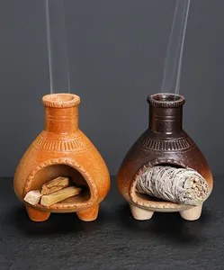Dettaglio di bruciatori in ceramica con salvia bianca e bastoncini di palo santo.