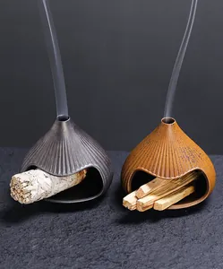Ceramic fireplace-style incense burners for sage and palo santo in two earthy colors.