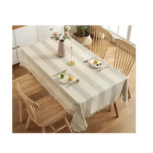 Nappe élégante en coton et lin à rayures grises avec pompons blancs pour la table.