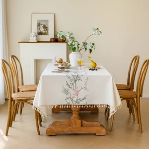 Detail view of embroidered floral tablecloth with elegant tassel fringe