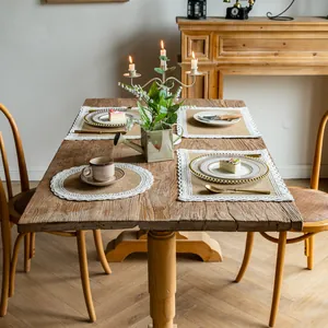Sets de table vintage en jute avec bordure en dentelle blanche sur une table en bois