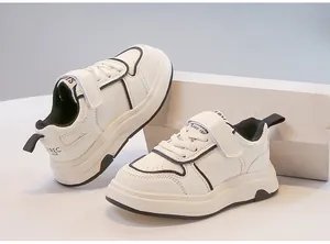 Vista laterale dettagliata di sneakers bianche per bambini con finiture nere e velcro