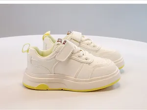 Vista dettagliata delle scarpe sportive bianche per bambini con accenti gialli e velcro