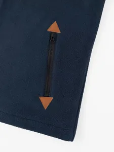 Close-up of navy polar fleece hoodie with zipper pocket and brown triangular patches