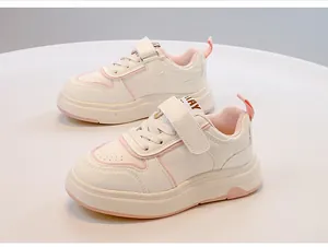 Eleganti sneaker casual bianche e rosa per bambini con chiusure a strappo su tavolo