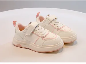 Primo piano di sneakers bianche e rosa per bambini con cinturini in velcro e lacci