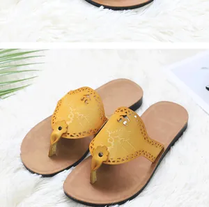Detailed view of yellow PU leather sandals with laser-cut floral patterns and a non-slip sole.