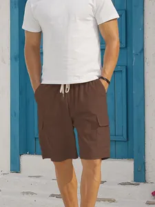 Detail view of men's brown corduroy cargo shorts featuring drawstring waist on a model.