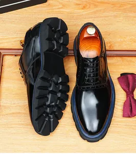 Gros plan de chaussures habillées noires brillantes avec semelles crantées et liseré bleu.