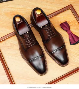 Vista detallada de zapatos Oxford de cuero marrón con tachuelas metálicas decorativas