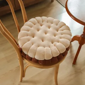Detailed view of a soft plush biscuit-shaped circular seat cushion on a wooden chair.