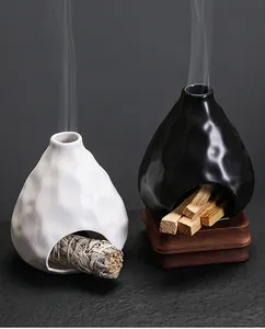 Quemadores de salvia cerámicos en blanco y negro con palos de palo santo y humo suave
